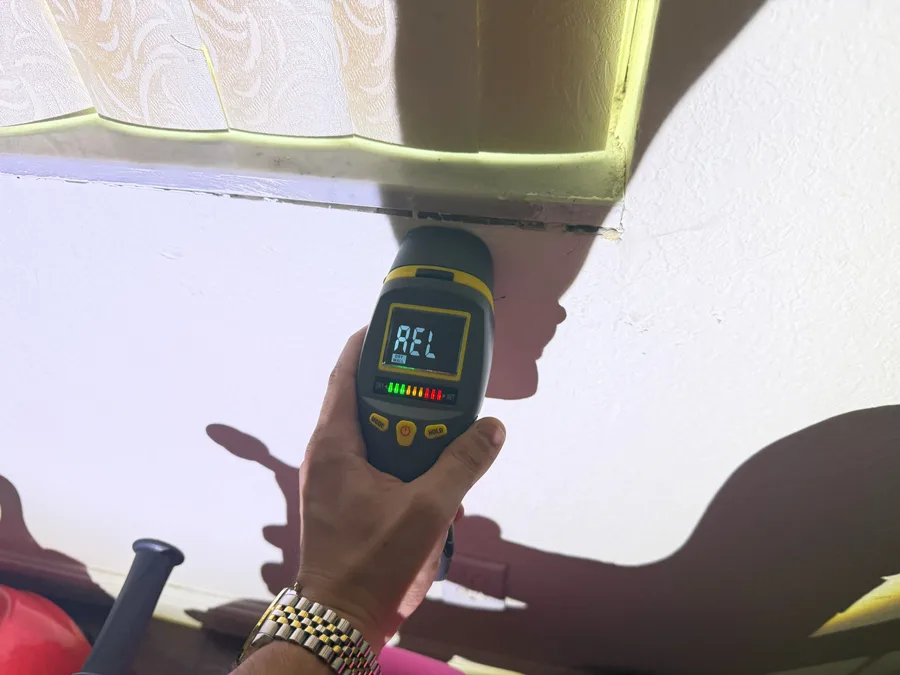 Moisture meter reading at a stained ceiling